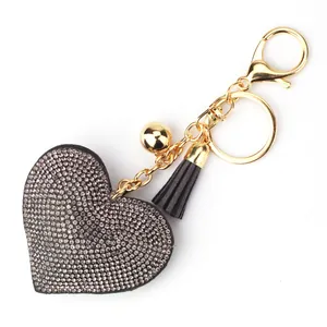 Close-up detail of heart rhinestone keychain featuring black tassel and gold plating