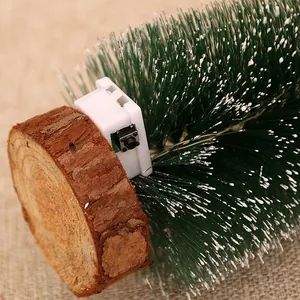 Close-up of mini Christmas tree base showing the wooden stand and power switch