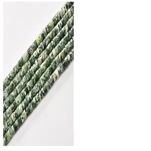 Detailed view of 2x4mm green and white patterned cylindrical tube beads for DIY jewelry.