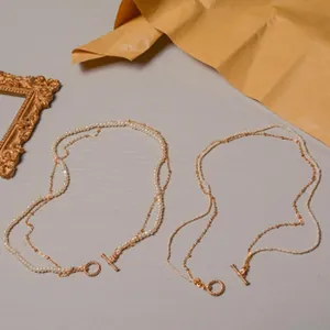 Close-up of double-layered freshwater pearl necklace with golden toggle clasp.
