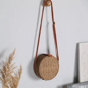 Sac à bandoulière rond en paille fait main dans un décor bohème rustique épuré