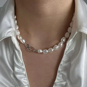 Close-up of baroque freshwater pearl necklace with silver link clasp on model's neck