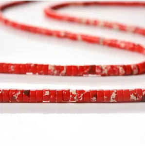 Close-up macro view showing the unique texture of red 2x4mm cylindrical tube spacer beads.