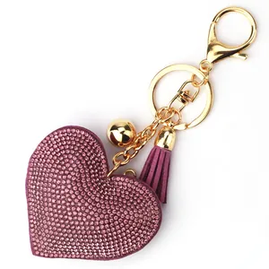Detailed macro shot of pink heart keychain with glittering rhinestones and purple tassel