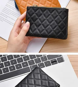 Close-up detail of a black quilted leather coin purse featuring a smooth top zipper
