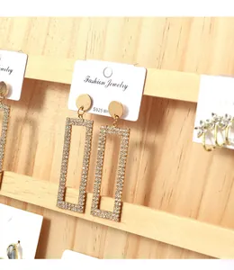 Close-up of minimalist multi-tier wooden display stand holding jewelry cards