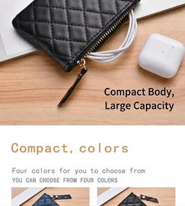 Close-up of a black quilted coin purse with zipper and white charging cable.