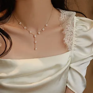 Elegant hand-woven flower freshwater pearl necklace with gold tassel pendant detail.