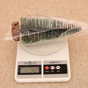 Miniature frosted Christmas tree decoration weighing 42 grams including packaging.