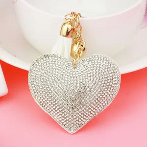 Close-up detail of a heart-shaped keychain with sparkling rhinestones and white tassel