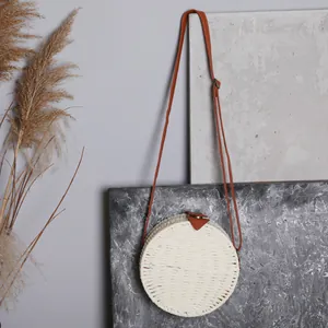 Sac à bandoulière rond en paille tissée à la main avec un style bohème vintage chic.