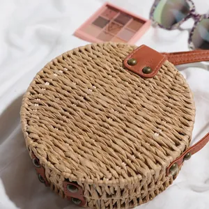 Vue détaillée d'un sac de plage rond en paille rétro avec une texture tressée artisanale