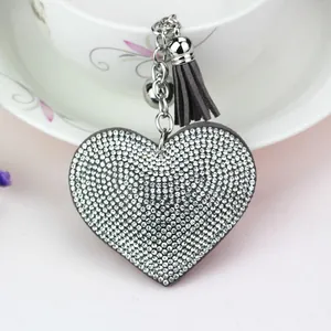 Close-up of a sparkling heart-shaped rhinestone keychain with a grey tassel pendant