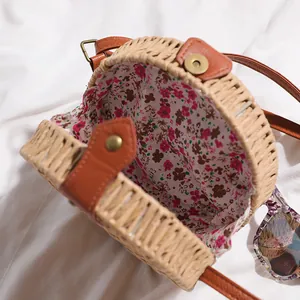 Détail en gros plan d'un sac de plage rond en paille tressée avec une doublure florale vive