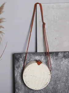 Sac à bandoulière rond en paille tissée blanche avec lanière en cuir marron vintage