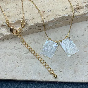 Elegante goldene Edelstahlkette mit zwei religiösen Anhängern aus weißem Perlmutt-Design