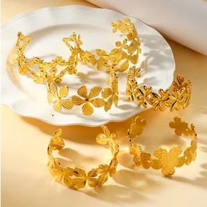Detailed close-up showing various gold-tone titanium steel open cuff floral bracelets