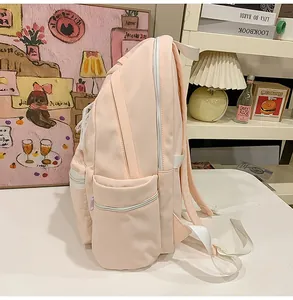 Side view detail showing the pockets of a light pink large capacity student backpack