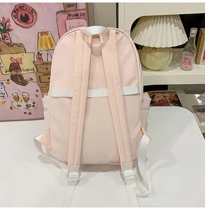 Detailed back view of a light pink student backpack with adjustable white shoulder straps