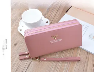 Close-up detail of a dusty rose women's double-zipper long wallet with golden deer logo