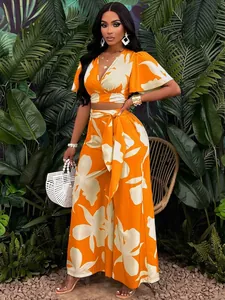 Ensemble deux pièces tropical orange avec manches papillon et pantalon à jambes larges.