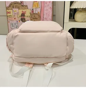 Bottom view detail of a light pink casual student backpack with sturdy white straps