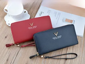 Detail view of double zipper women's long wallets in red and blue textured leather finish.