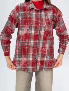 Close-up view of the red distressed plaid shirt featuring buttons and a chest pocket