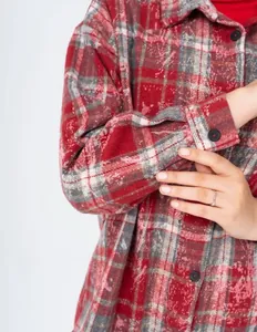 Detailed macro view of a vintage red and grey plaid flannel shirt sleeve texture