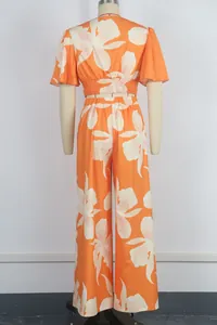 Rear view of vibrant orange tropical floral print butterfly sleeve top and pants set.