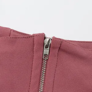 Detail view of the silver metal zipper and ribbed fabric of the mauve corset top.