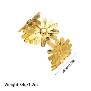 Detailed macro view showing the golden daisy design of this stainless steel open bangle