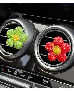 Detail view of sparkling rhinestone flower car air vent clips in green and red colors