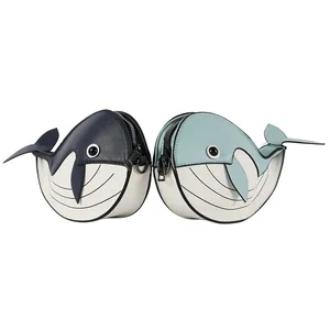 Close-up detail of cute whale-shaped crossbody bags in blue and white contrast colors