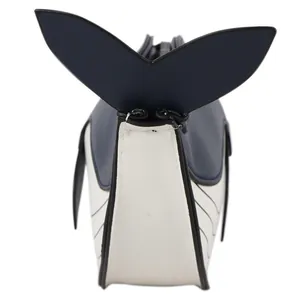 Detail view of a cute cartoon whale-shaped crossbody bag in navy blue and white.