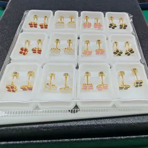 Detailed macro view of colorful butterfly stud earrings set in a white plastic tray