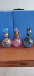 Detailed close-up of mystical resin potion bottles with glitter and metallic motifs.