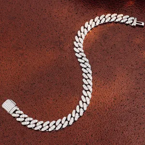 Macro detail of iced-out moissanite Cuban link bracelet with sparkling stones on brown texture.