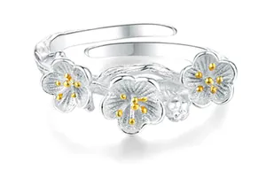 Detailed view of a silver floral open ring with matte petals and gold centers.