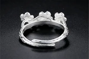 Detailed macro view of forest-style silver ring with three-petal design and branch texture