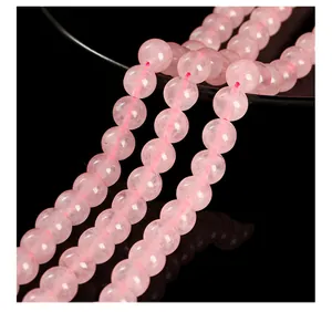 Close-up of natural rose quartz round beads showing delicate pink color and texture.