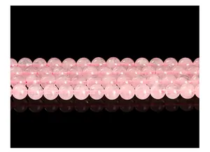 Close-up macro shot of natural round pink rose quartz beads showing smooth texture and clarity