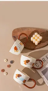 Detailed view of three ceramic mugs featuring adorable cartoon dog patterns and I wanna jump text