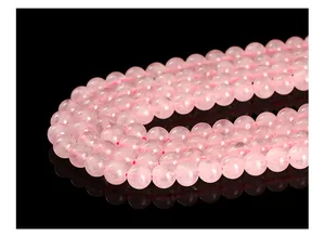 Close-up macro detail of natural Madagascar rose quartz round beads with smooth finish