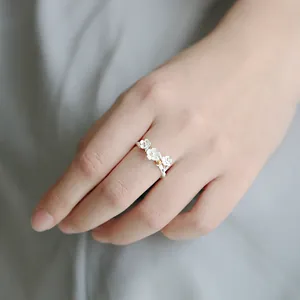 Elegant silver open ring featuring delicate white flower petals and gold center accent