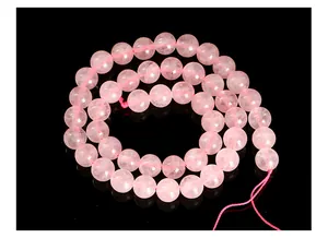 Macro detail of natural round pink rose quartz crystal beads for DIY jewelry craft projects