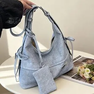 Stylish light blue textured hobo bag with a matching small pouch and bow details