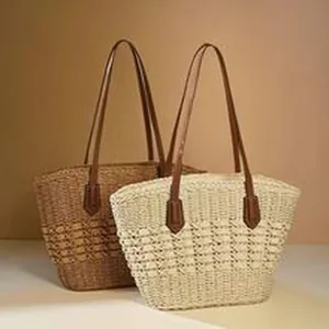 Detail view of two minimalist ethnic style woven straw tote bags in beige and brown colors.
