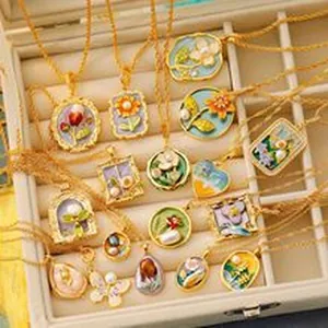 Vintage gold necklaces with enamel floral and butterfly pendants in a jewelry box