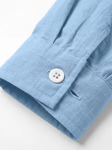 Vue détaillée d'un poignet de chemise bleu clair en coton lin avec un bouton blanc